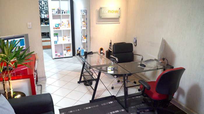 Recepção da loja Fixnow, com mesa de atendimento e logotipo na parede